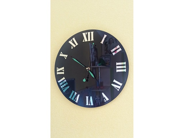 Настенные часы черного цвета с зеркальными цифрами.