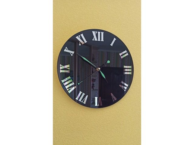 Настенные часы черного цвета с зеркальными цифрами.